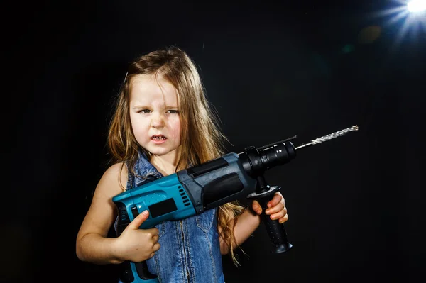 Linda niña con máquina de perforación en sus manos — Foto de Stock