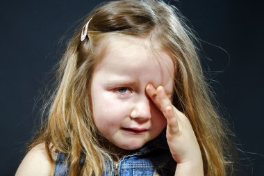 Crying blond little girl with focus on her tears clipart