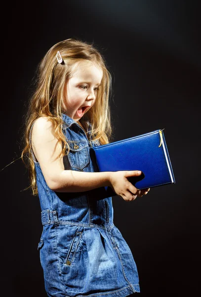 Gelukkig meisje met blauwe boek in haar handen — Stockfoto