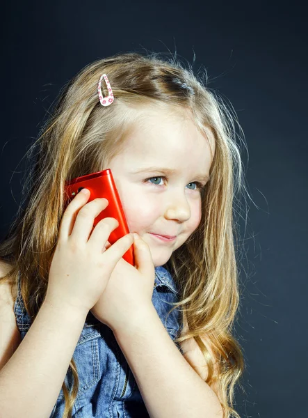 Linda niña habla usando un nuevo teléfono celular . — Foto de Stock