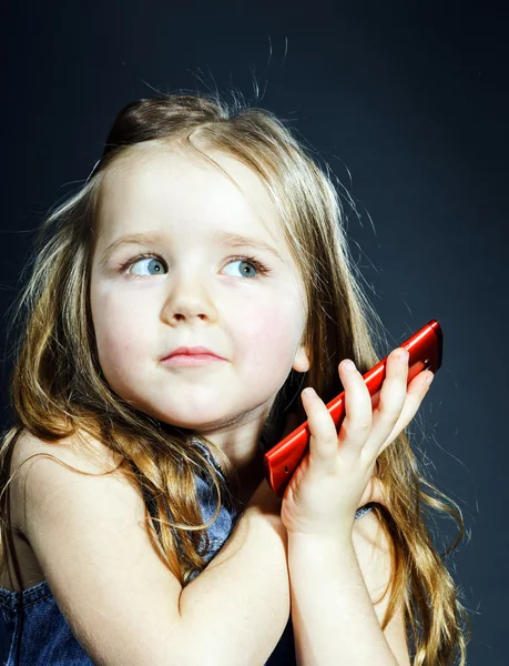 Linda niña habla usando un nuevo teléfono celular . — Foto de Stock