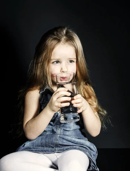Cute little girl drinking clear water — Stock Photo, Image