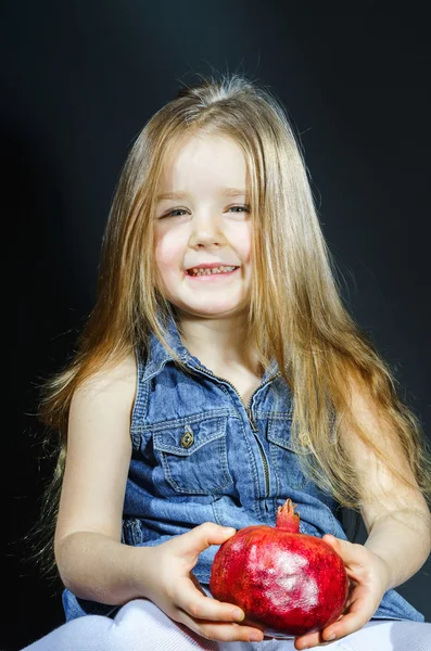 Gadis kecil yang lucu berpose dengan delima merah — Stok Foto