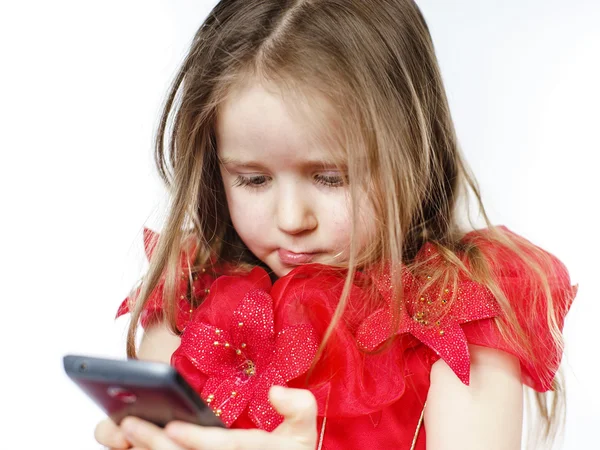 Cute little girl dressed in ball gown playing with smartphone — Stock Photo, Image