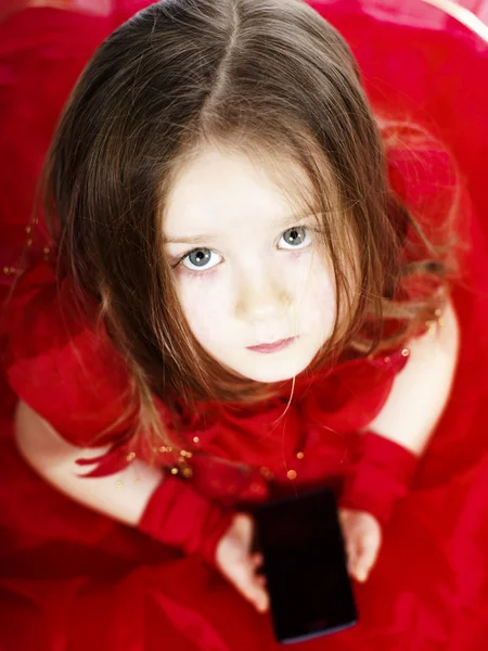 Linda niña vestida con vestido de bola jugando con el teléfono inteligente — Foto de Stock