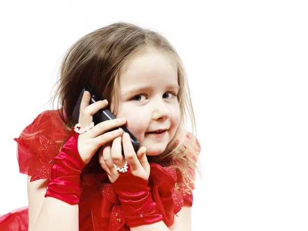 Cute little girl dressed in ball gown playing with smartphone — Stock Photo, Image