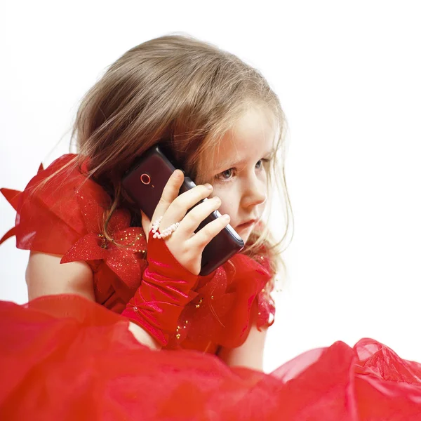 Carino bambina vestita in abito da ballo giocare con lo smartphone — Foto Stock