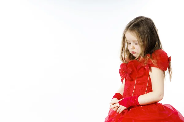 Carino bambina vestita in rosso in posa in studio — Foto Stock