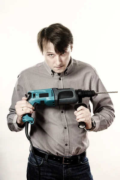 Young man with electric drilling machine isolated on white — Stock Photo, Image