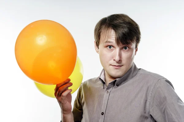 Junger kaukasischer Mann mit gelben Luftballons in der Hand — Stockfoto