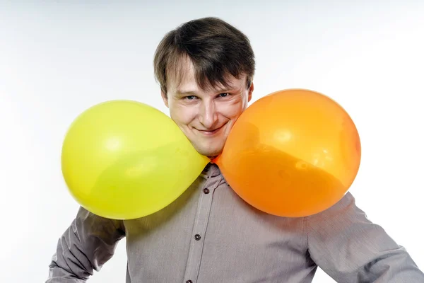 Joven hombre caucásico sosteniendo globos de aire amarillos en su mano — Foto de Stock