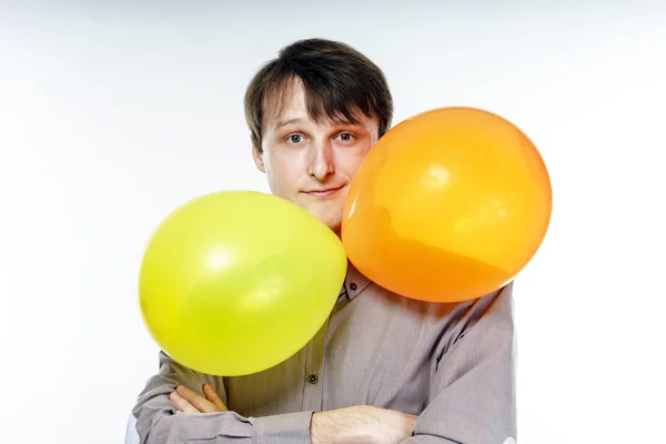 Joven hombre caucásico sosteniendo globos de aire amarillos en su mano —  Fotos de Stock