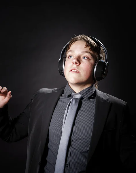 Мальчик-подросток слушает музыку в наушниках — стоковое фото