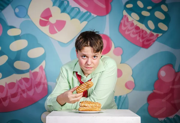 Funny boy eating sweet cakes, hungry and candy man — Stock Photo, Image