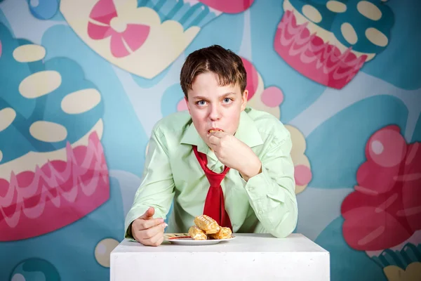 Funny boy eating sweet cakes, hungry and candy man — Stock Photo, Image