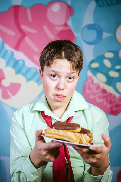 Engraçado menino comer bolos doces, fome e doces homem — Fotografia de Stock