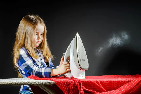 Niedliches kleines Mädchen, das deiner Mutter hilft, indem es Kleidung bügelt, — Stockfoto