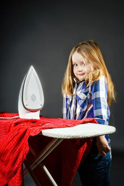 Niedliches kleines Mädchen, das deiner Mutter hilft, indem es Kleidung bügelt, — Stockfoto