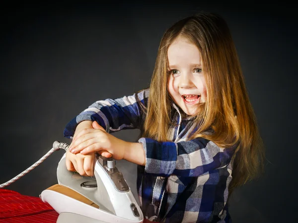 Niedliches kleines Mädchen, das deiner Mutter hilft, indem es Kleidung bügelt, — Stockfoto