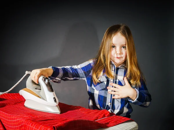 Niedliches kleines Mädchen, das deiner Mutter hilft, indem es Kleidung bügelt, — Stockfoto