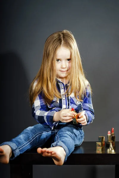 Petite fille mignonne avec les cosmétiques de la mère, portrait en gros plan — Photo