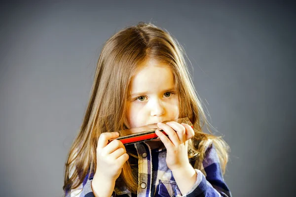 Linda niña tocando la armónica — Foto de Stock