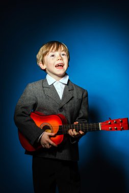 Kızıl saçlı okul öncesi çocuk ukalele, müzik konsepti ile