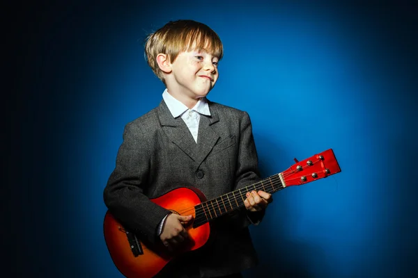 Rödhårig förskolebarn pojke med ukalele, musik koncept — Stockfoto