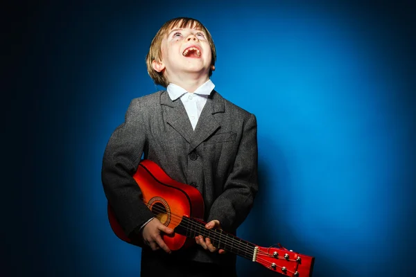 Menino pré-escolar de cabelos vermelhos com ukalele, conceito de música — Fotografia de Stock