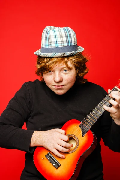 Red-hair funny teenage boy playing little guitar — Stock Photo, Image