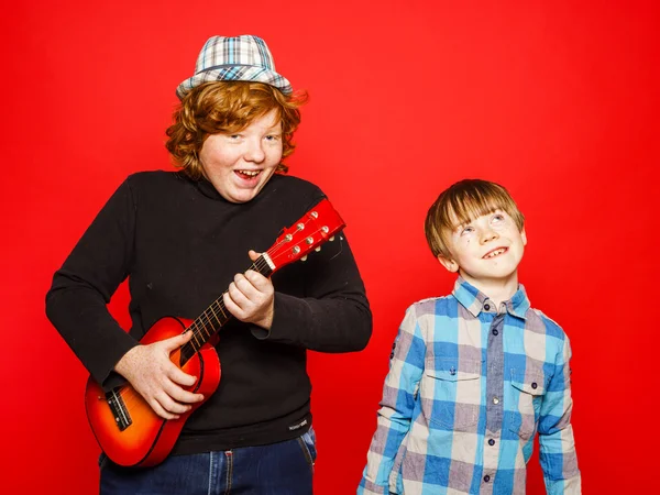 Two funny red-hair brothers playing music — Stock Photo, Image