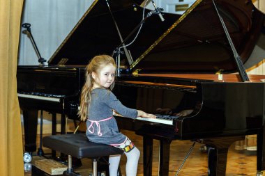 Grand piyano çalan sevimli küçük kız
