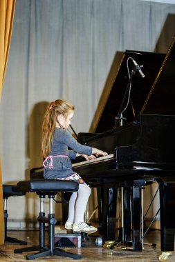 Grand piyano çalan sevimli küçük kız