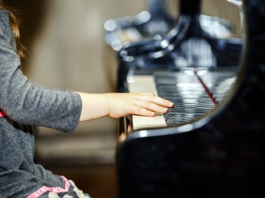 Grand piyano çalan sevimli küçük kız