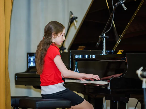 Teenage girl playing grand piano — Stock Photo, Image