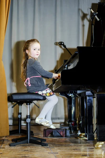 Menina bonito tocando piano de cauda — Fotografia de Stock