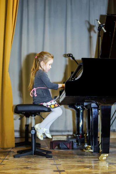 Cute little girl playing grand piano — Stock Photo, Image