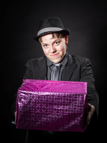 Expressive teenage boy holding box with gift — Stock Photo, Image