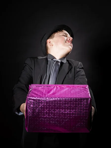 Expressive teenage boy holding box with gift — Stock Photo, Image