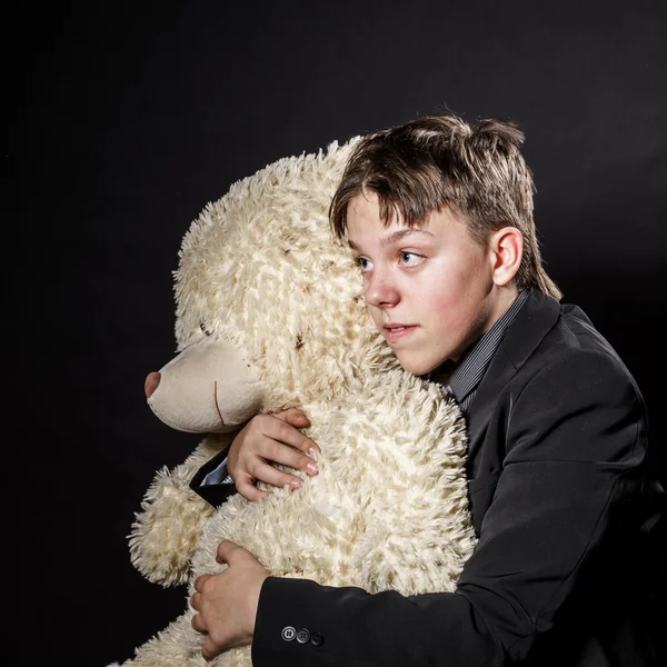 Teenage boy dressed in suit with his old toy - teddy-bear — Stock Photo, Image