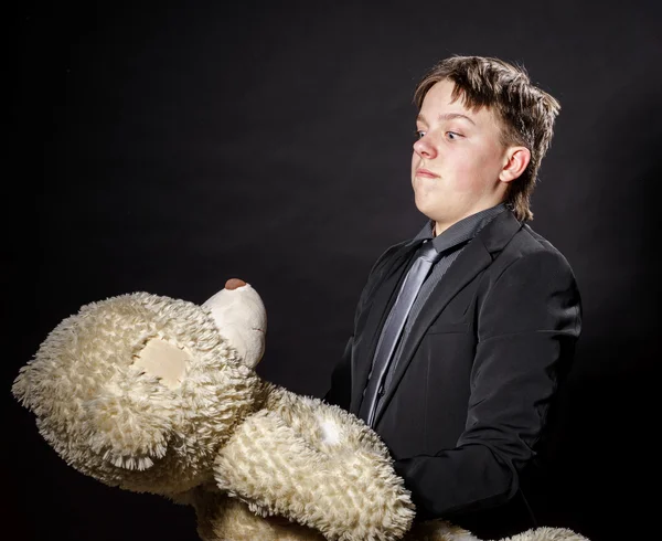 Tonårspojke klädd i kostym med sin gamla leksak - teddy-bear — Stockfoto