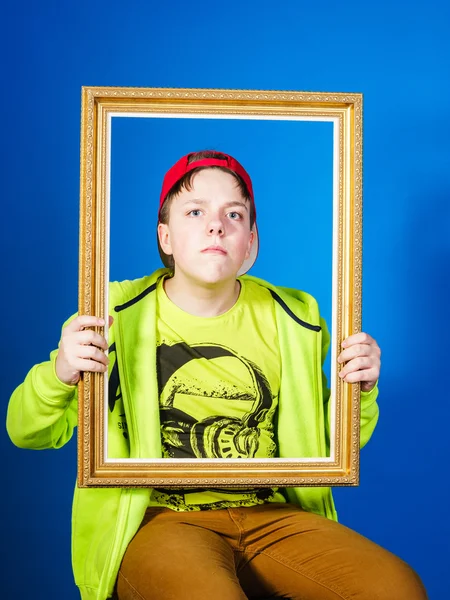 Affective teenage boy posing with picture frame — Stock Photo, Image