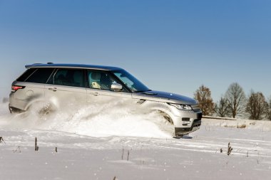 Powerful 4x4 offroader car running on snow field clipart