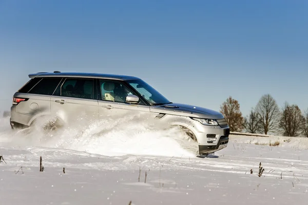 Potente coche todoterreno 4x4 corriendo en el campo de nieve — Foto de Stock