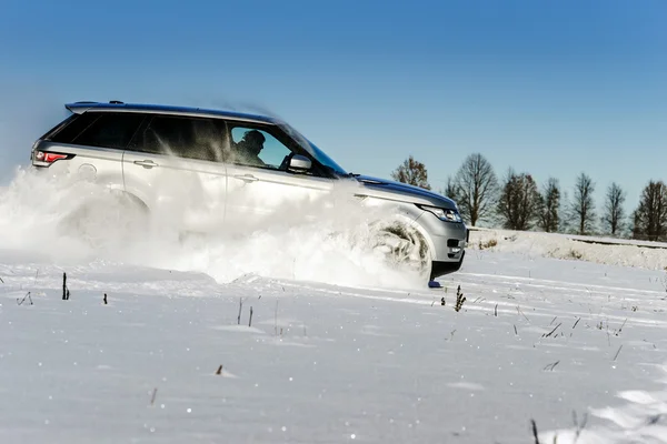 Poderoso carro offroader 4x4 rodando no campo de neve — Fotografia de Stock
