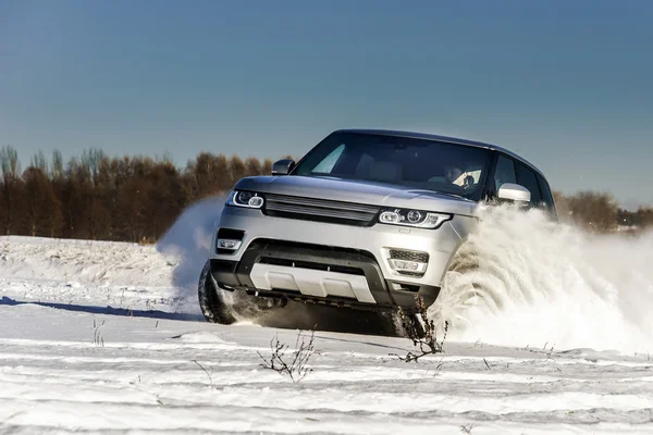 Potente coche todoterreno 4x4 corriendo en el campo de nieve — Foto de Stock