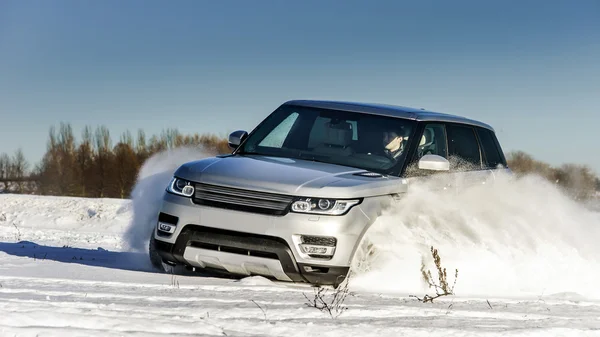 Potente coche todoterreno 4x4 corriendo en el campo de nieve — Foto de Stock