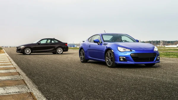 Comperison dos coches deportivos en el camino de la carrera — Foto de Stock