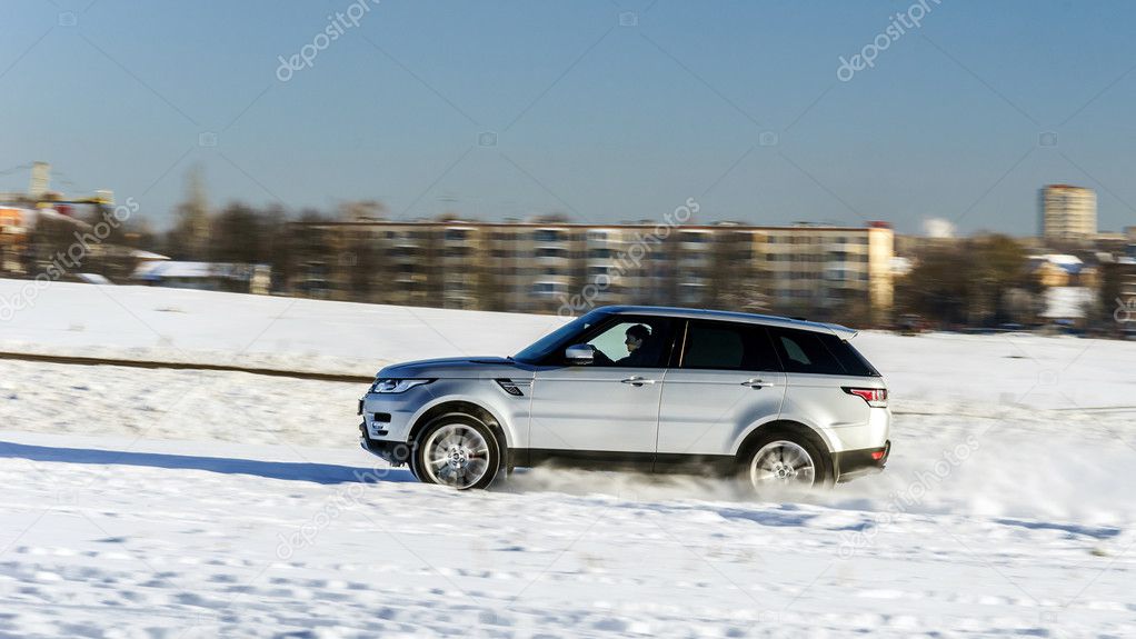 Powerful 4x4 offroader car running on snow field