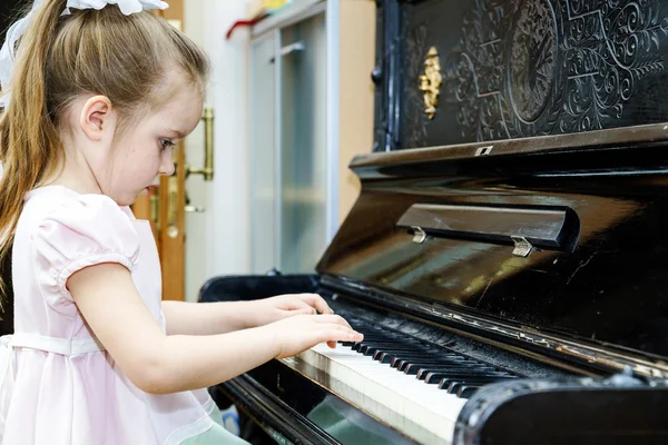 Menina bonito tocando piano velho — Fotografia de Stock